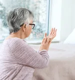 Mulher idosa de perfil olhando para as mãos